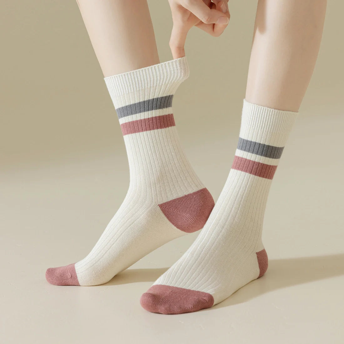 The socks are white with a pink and grey stripe around the top of the sock. The socks are also ribbed and have a pink toe and heel.